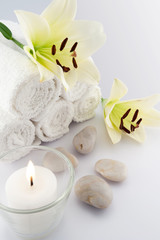Fototapeta na wymiar Towels with candle, stones and flowers