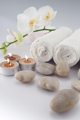 Fototapeta na wymiar White towels with orchid, stones and candle