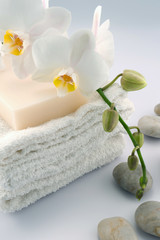 Fototapeta na wymiar White towels with orchid and stones