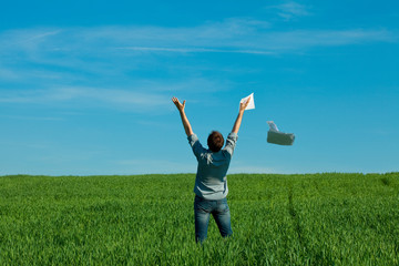 young man throwing a paper in the green field