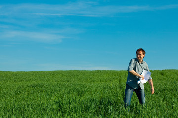 Naklejka na ściany i meble young man throwing a paper in the green field