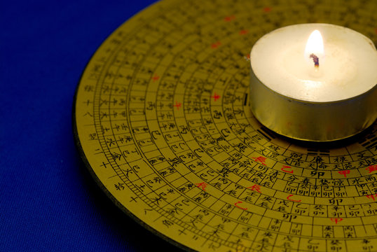 Chinese Feng Shui compass with the candle isolated on blue