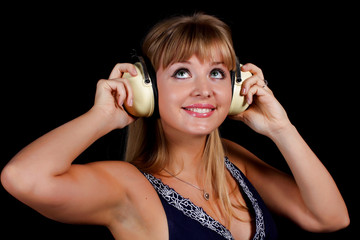 Fototapeta premium a charming young blonde on a black background with earphones