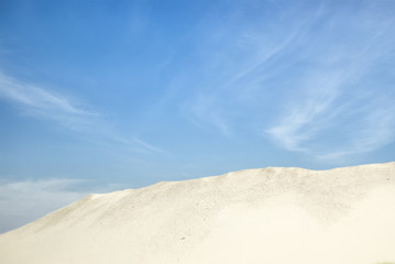 Fototapeta na wymiar Sandy horizon against blue sky with clouds.