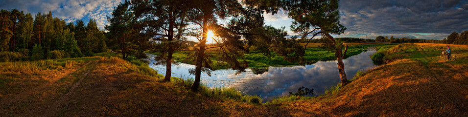 Summer panorama with river and pine-tree on sunset