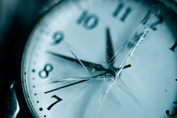 Broken time concept. Old dusty pocket clock with broken glass. S