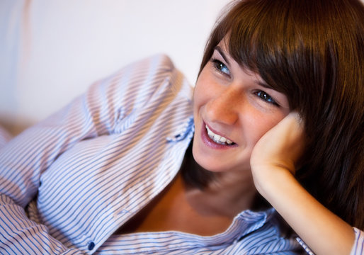 Smiling happy young woman relaxing on sofa