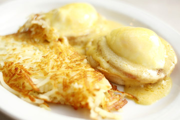 Eggs benedict and hash brown potatoes