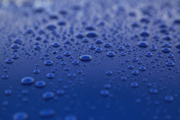 rain drops on a blue car body, shallow focus