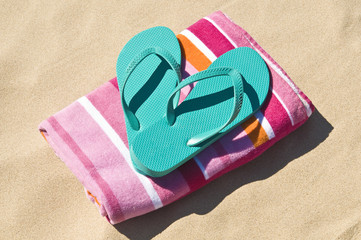 Fototapeta na wymiar Flip-flops and towel at the beach.