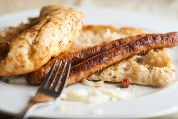 two beed sausages on flatbread with onion