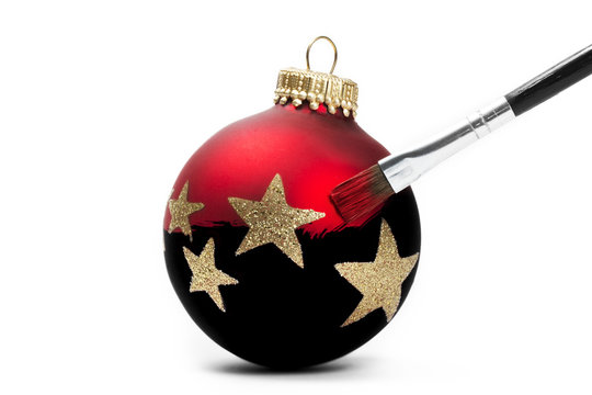 rote christbaumkugel mit glittersternen bekommt farbe