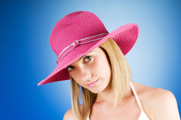 Young girl with beach hat against gradient background