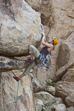 Rock climber clinging to a steep cliff.