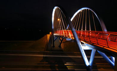 Pedestrian bridge over road at night