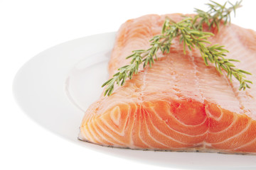 fresh uncooked salmon fillet on plate with rosemary