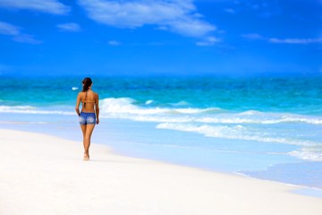 Fototapeta na wymiar Młoda dziewczyna chodzenie na tropikalnej plaży