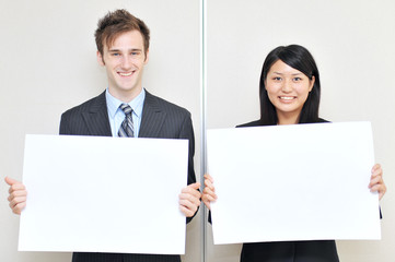 two business person holidng a white board