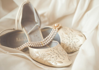 Beautiful luxury white wedding shoes with pearl necklace