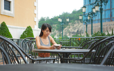 girl watching videos on portable devices in cafe