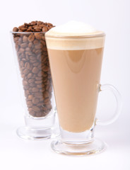 Glass of caffe latte with a glass of coffee beans on white