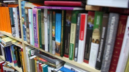 books on bookshelfs in bookshop, vertical panning, defocused - Powered by Adobe