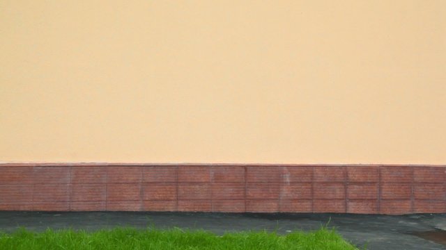 boy in elbow pads and knee-pads rollerblading against wall