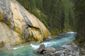 Flowing River next to red rock in Jognson Canyon