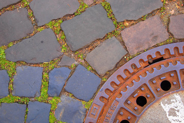 Kopfsteinpflaster mit Gullydeckel