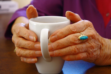 Alte H&auml;nde umfassen eine Tasse