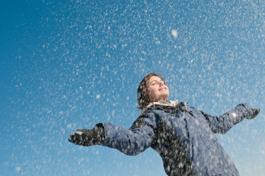 Enjoying winter - woman throwing snow
