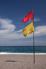 Red and yellow flags on the Taormina beach