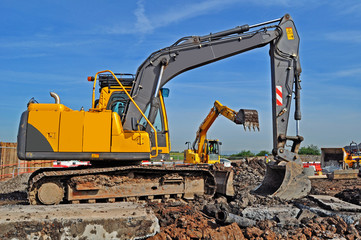 Close Up of a couple of yellow excavators at work on a building site 