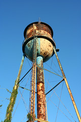 Old rusty watertower against blue sky