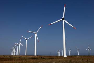 Farm of wind turbines against a blue sky