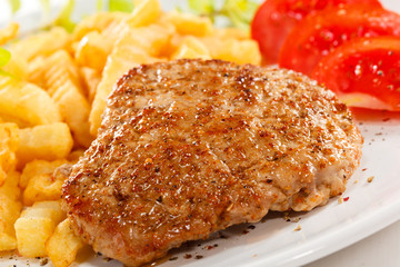 Fried pork chop with chips and vegetables