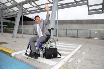 Businessman in wheelchair waiting for a taxi