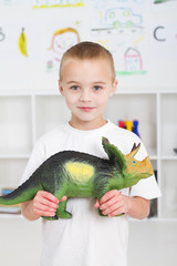 preschool boy playing with dinosaur