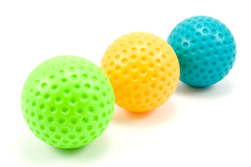 three colored golf balls over a white background