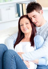 Enamored young couple lying together on the sofa