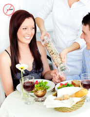 Obraz na płótnie Canvas Cheerful young couple dining at the restaurant