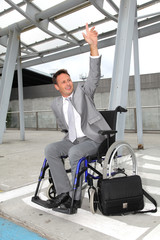 Fototapeta na wymiar Businessman in wheelchair waiting for a taxi