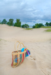 Bag with towel on the sand.