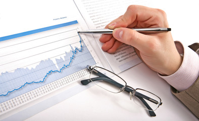 Businessman's hand showing diagram on financial report with pen