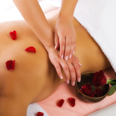 Massage mit Rosen in goldenem Licht