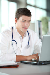 Young doctor in front of laptop computer