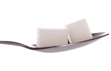 Two white sugar cubes on tea spoon