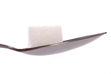 White sugar cube on tea spoon