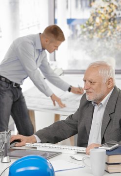 Businessman working with colleague in background