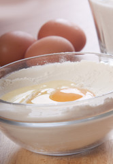 glass bowl with flour and broken egg